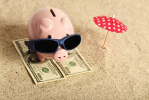 Piggy-bank-on-the-beach-with-sunglasses